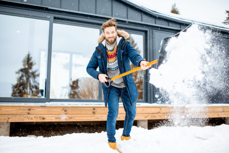 Image of man cleaning snow near the house